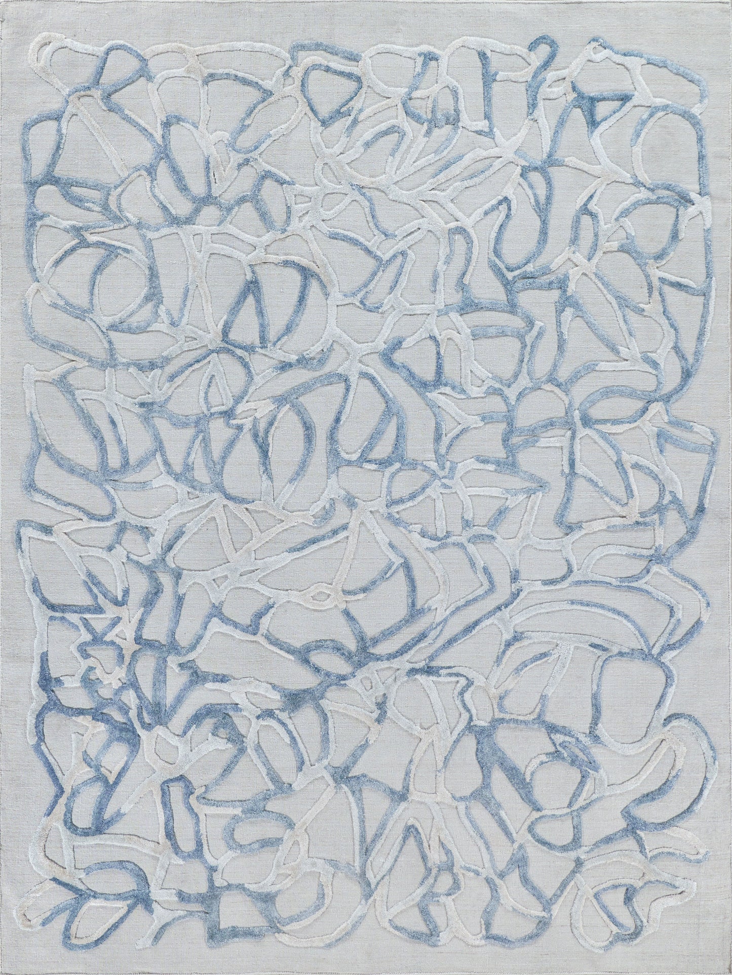 Abstract blue and white hand-loomed rug with a textured surface and looping rope-like patterns; indoor decor.