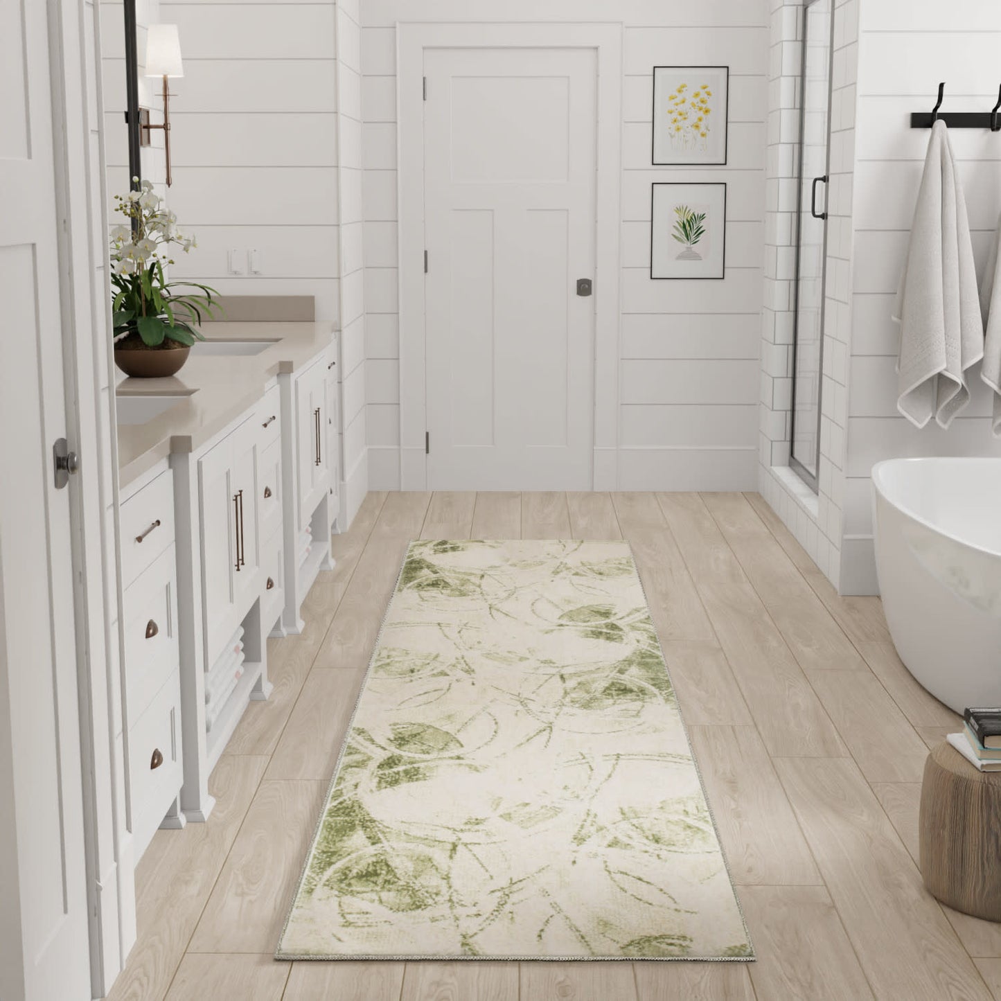 Cream botanical runner rug with green leaf pattern in a white modern bathroom with wood-tone plank floor and freestanding tub