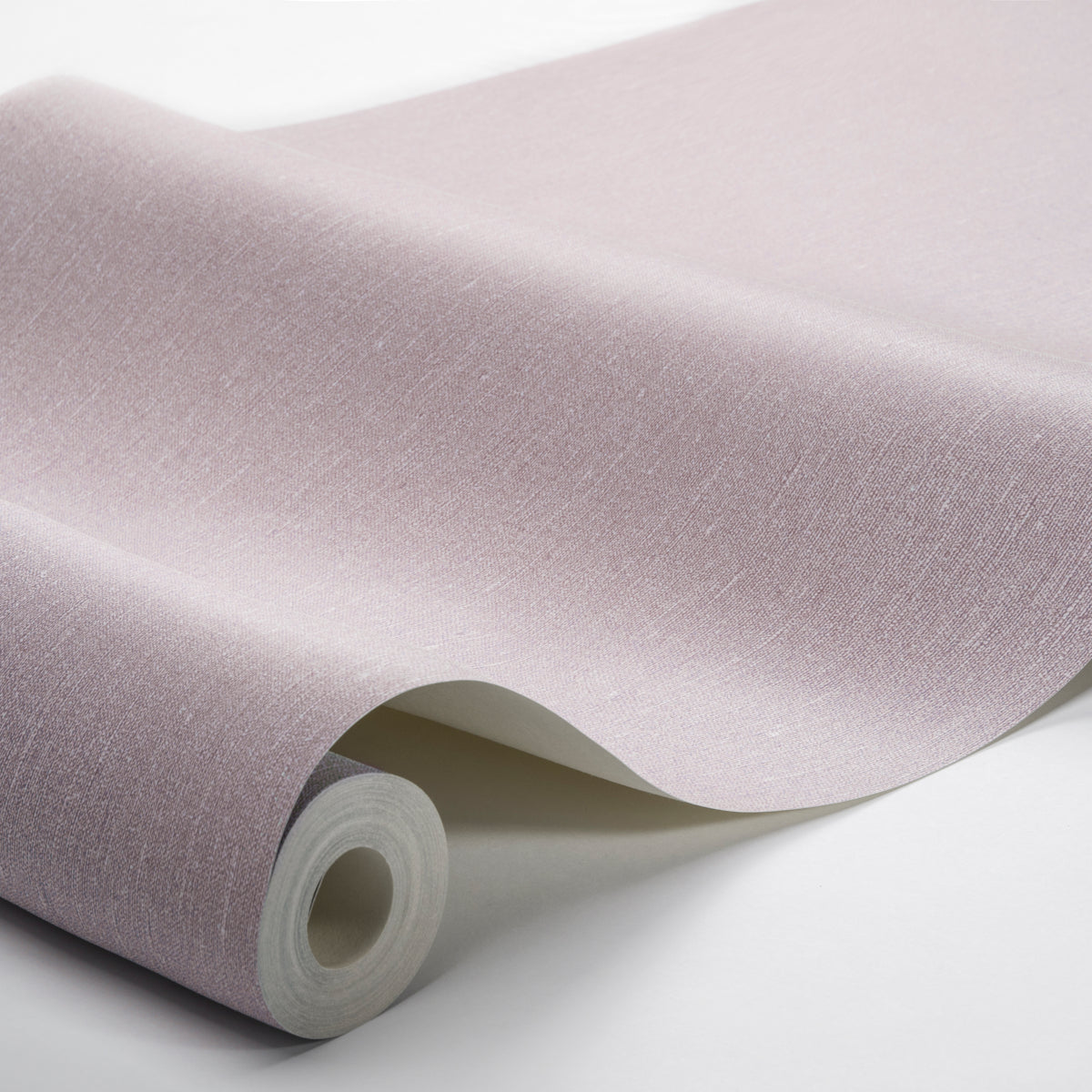 Pastel lavender wallpaper roll with a linen texture, curling edge as it unfurls.