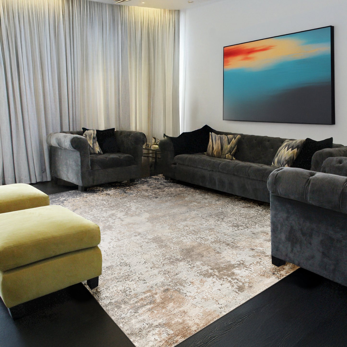 Modern grey velvet living room with tufted sofas, yellow ottomans, beige rug, light curtains, and abstract blue-orange wall art.