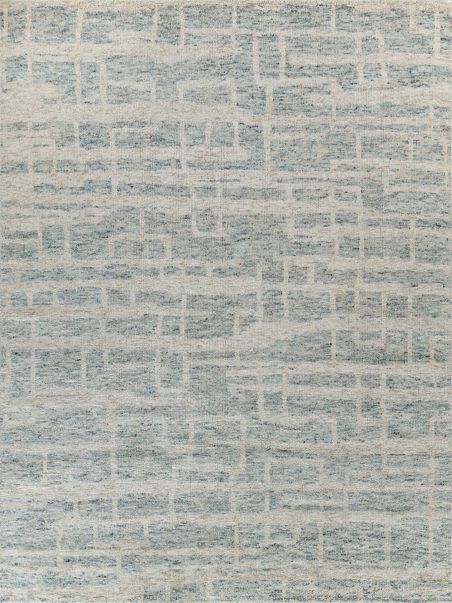 Rectangular woven rug in light blue and ivory with a distressed geometric pattern, modern casual living room decor.