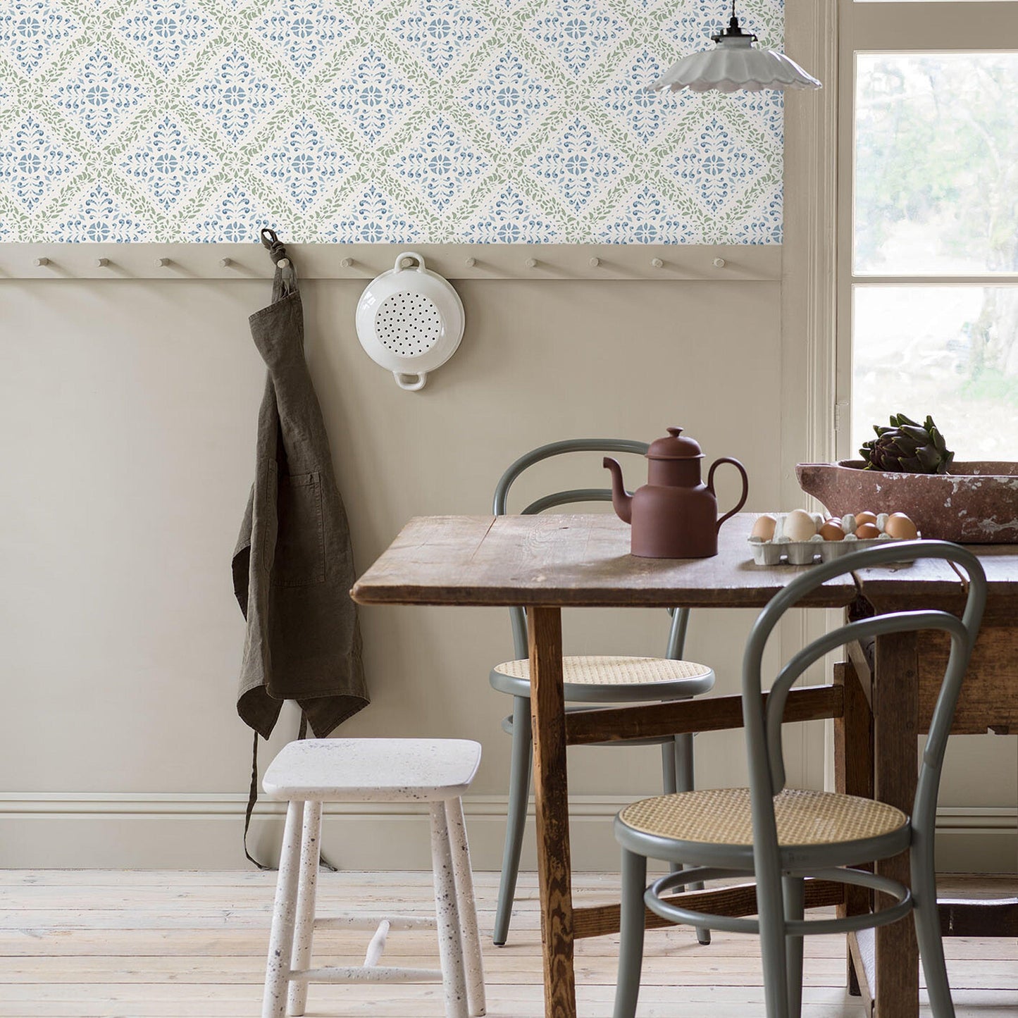 Blue and green patterned wallpaper on the wall in a cozy room.
