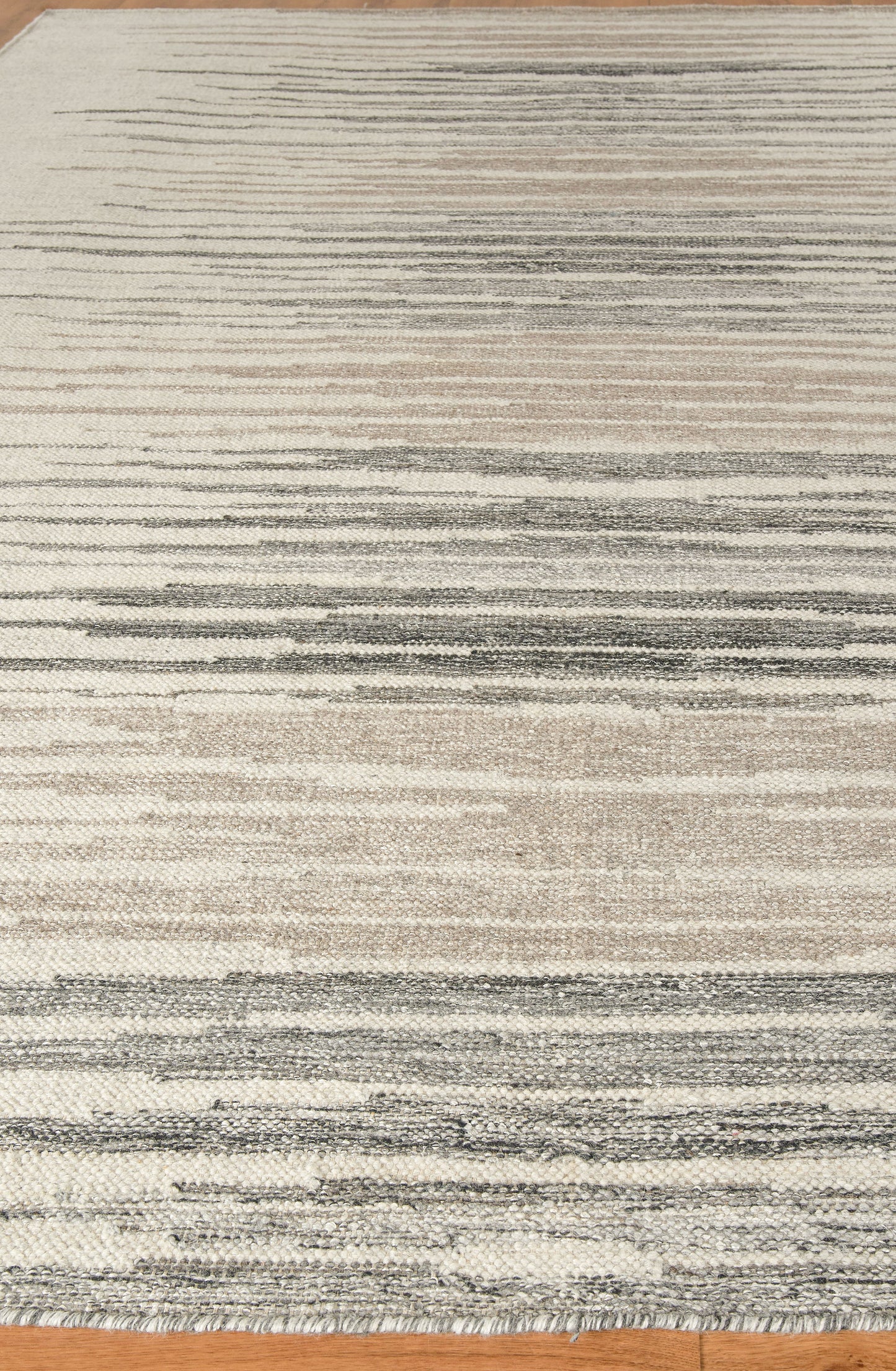 Rectangular area rug with cream, beige and gray horizontal stripes in a modern abstract pattern.