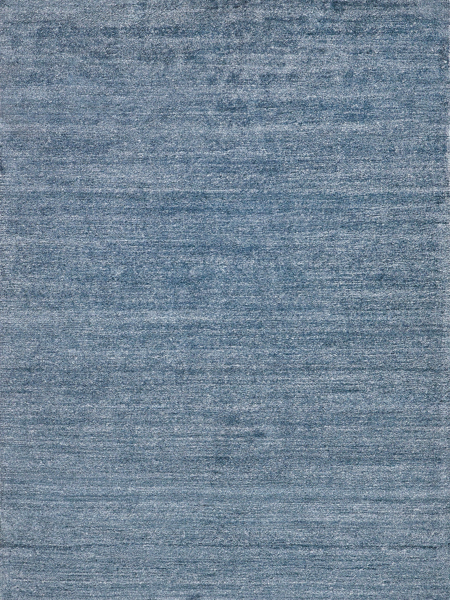 Rectangular denim blue textured rug with subtle variegation; plush indoor hand-knotted rug, 2' x 3'.