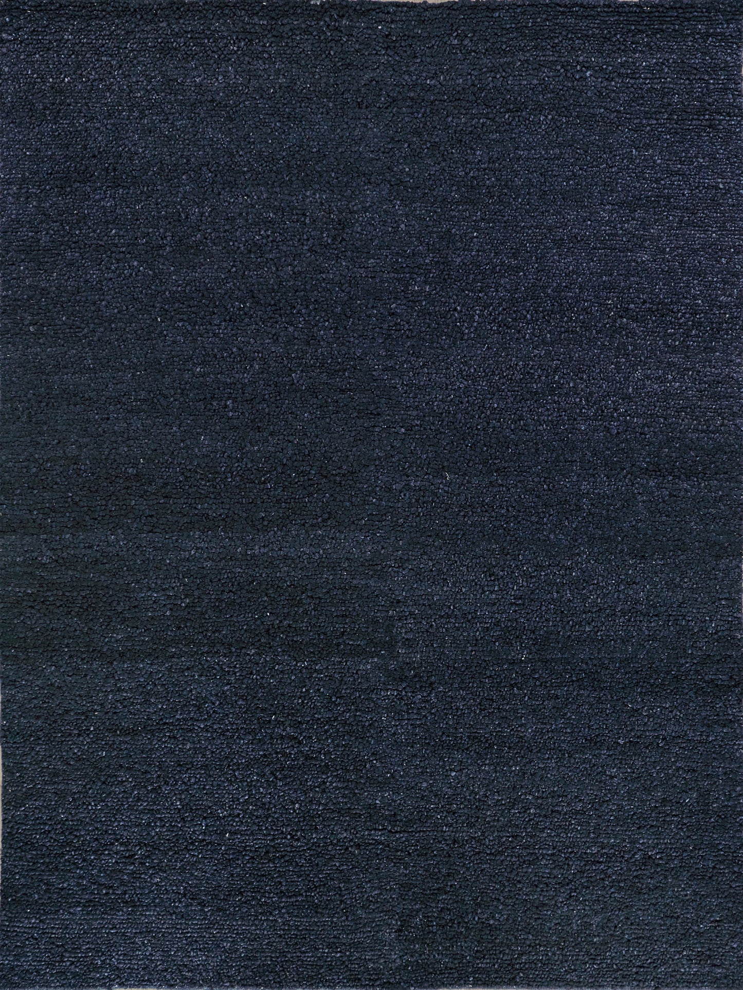 Dark navy blue textured rug with a soft, woven surface, suitable for modern or minimalist decor.
