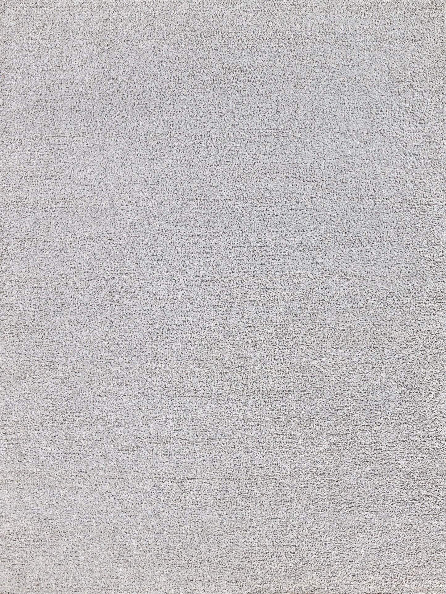 Close-up of light gray rug texture with dense loop pile.