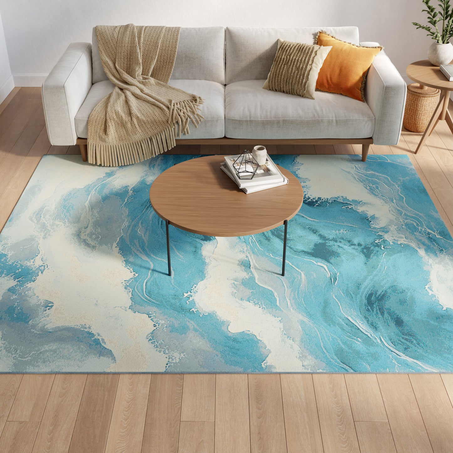 Light gray fabric sofa with beige throw, mustard cushion; round wood coffee table on blue marbled rug in modern living room.