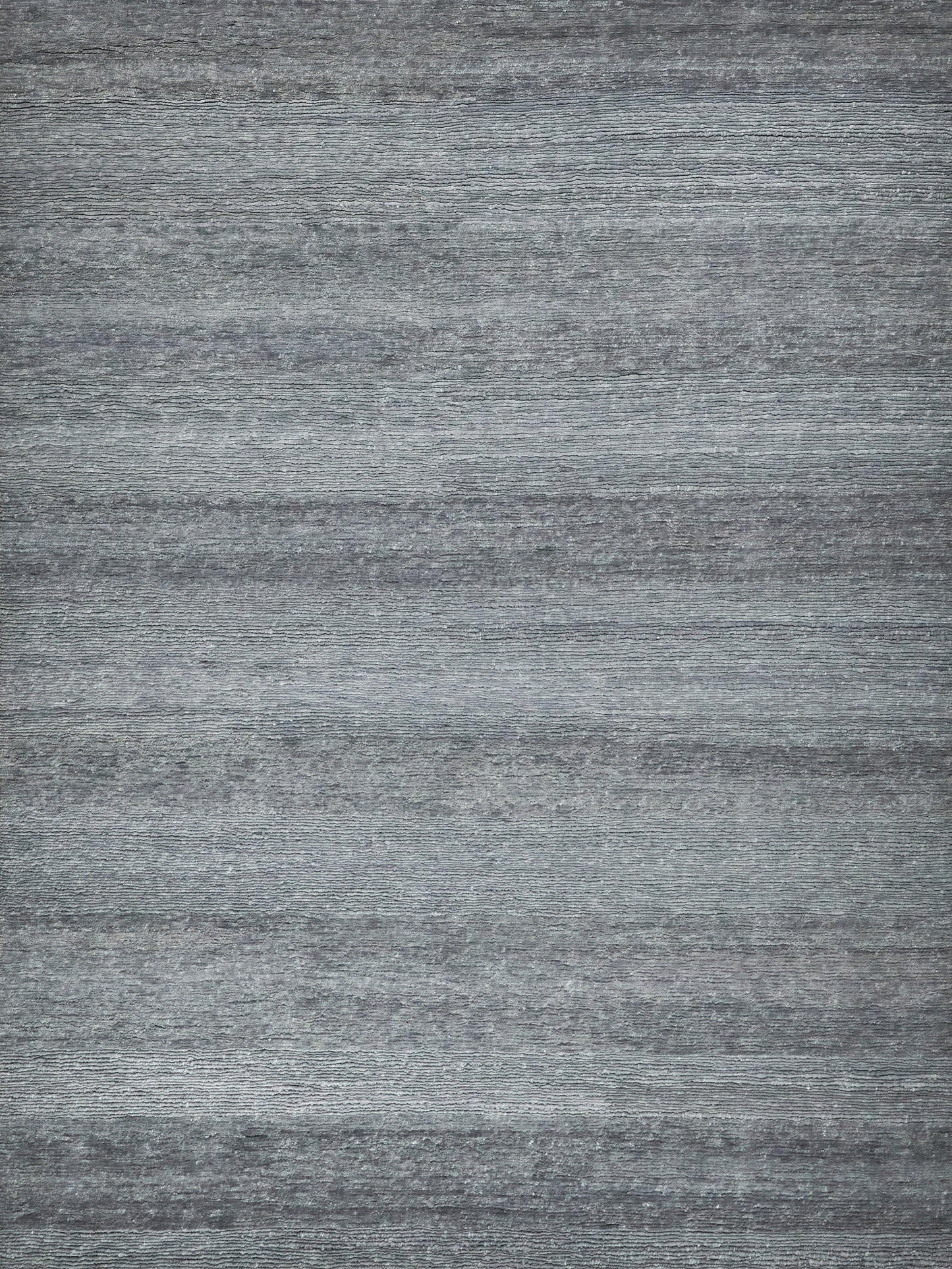 Blue-gray Merino wool indoor hand-knotted rug on a rustic wood backdrop.