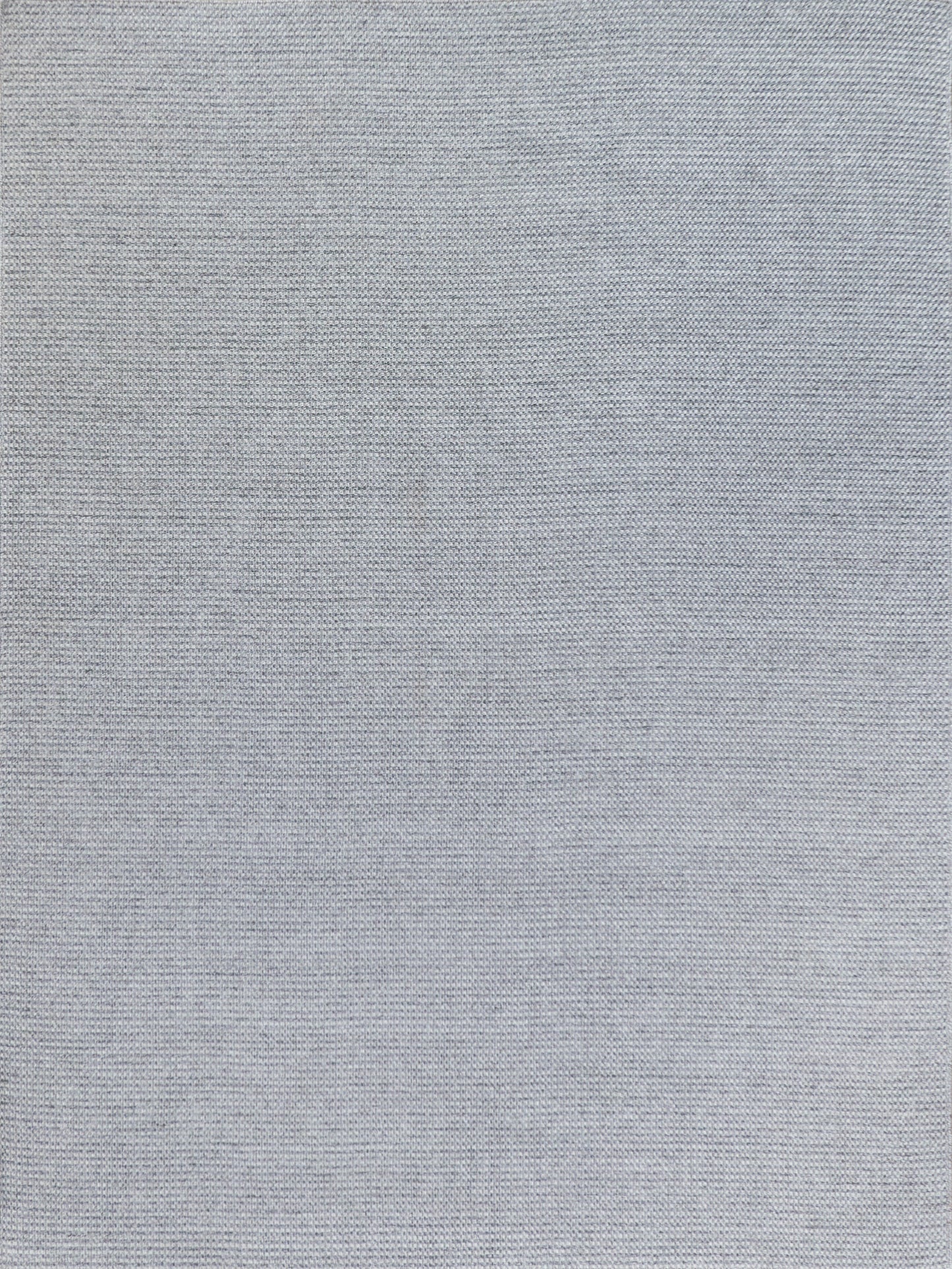 Light gray flatweave rug with a textured surface.