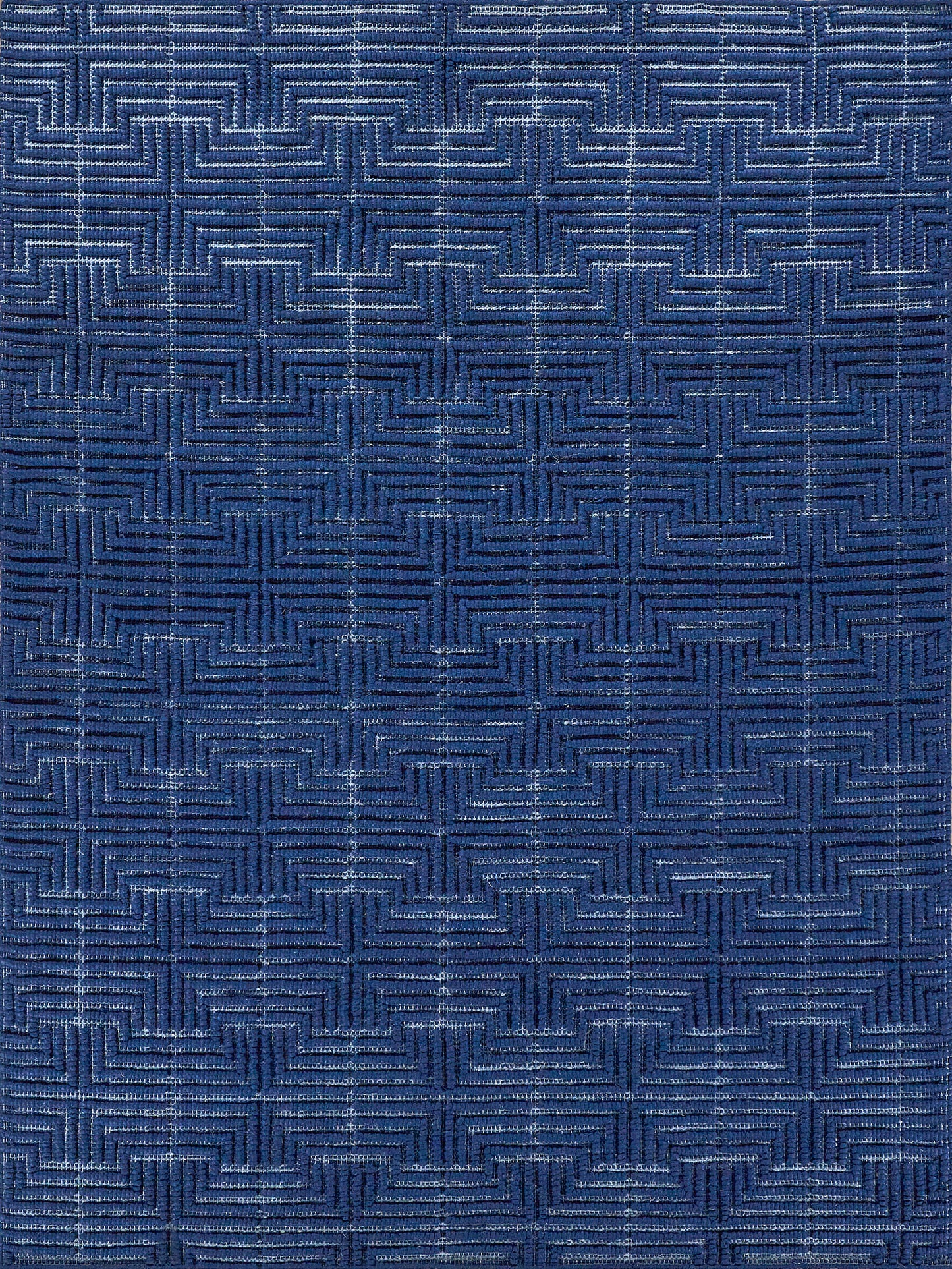 Deep blue textured rug with a geometric interlocking square weave pattern and subtle sheen.