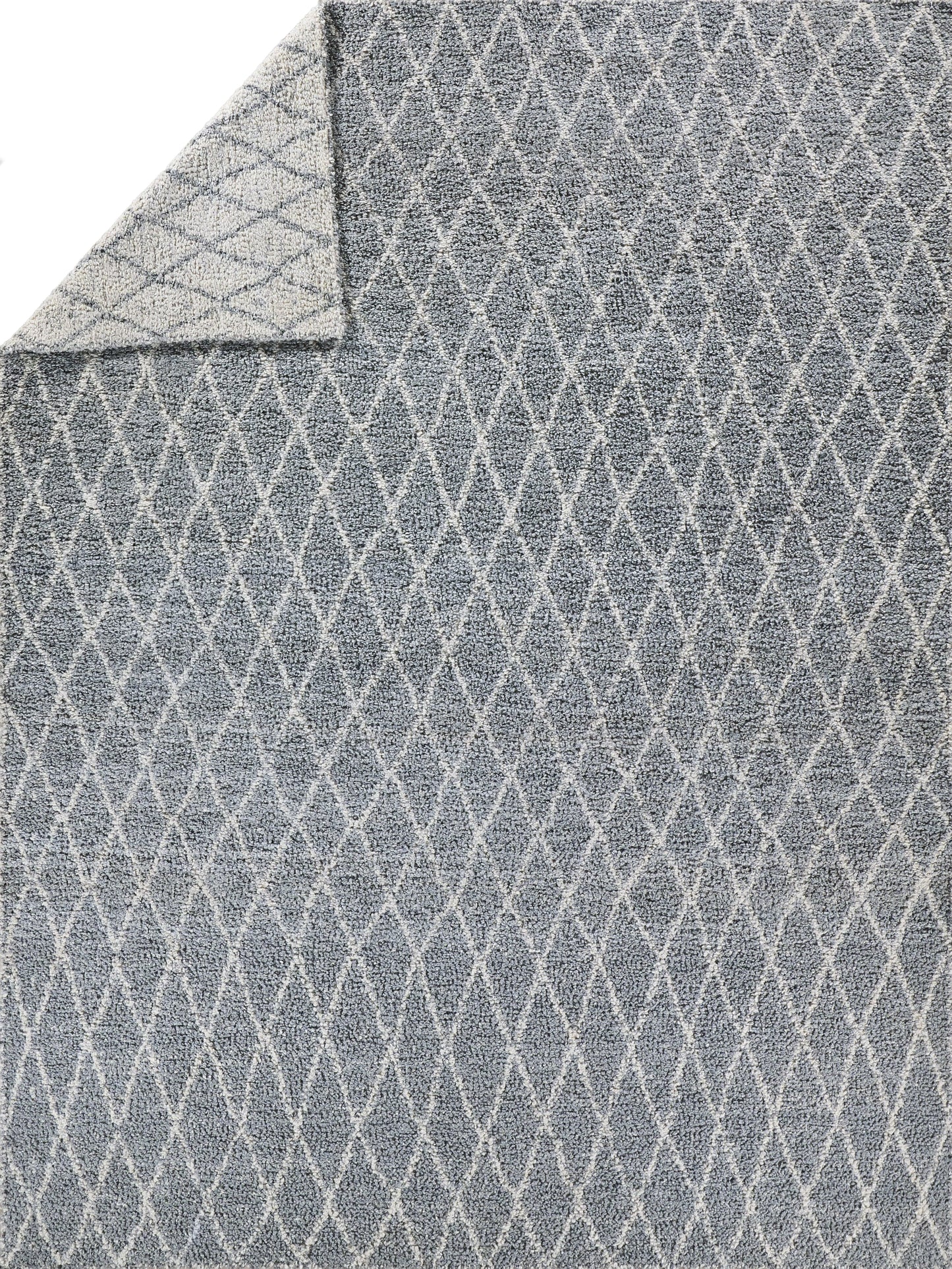 Gray-blue rug with white diamond lattice pattern; soft textured pile with folded corner.