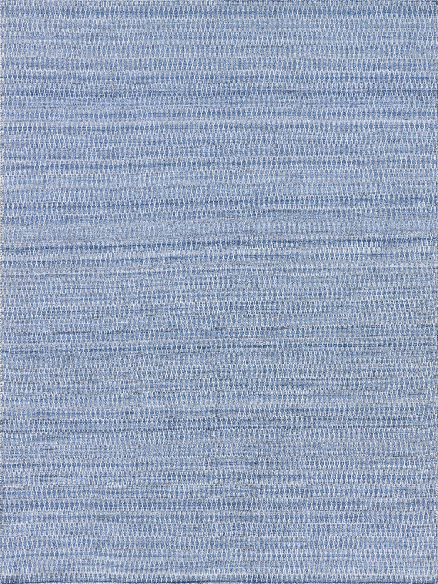 Light blue rectangular flatweave rug with a repeating geometric pattern.
