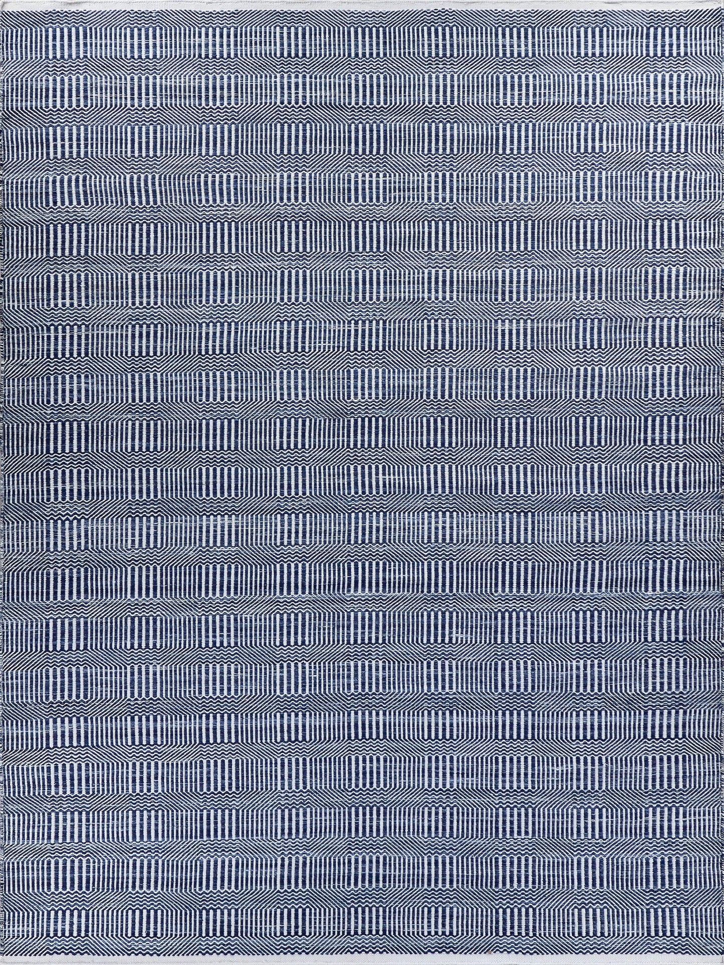 Rectangular navy blue and white rug with repeating geometric ring pattern and vertical lines; indoor/outdoor flat-weave rug, 5' x 8'.
