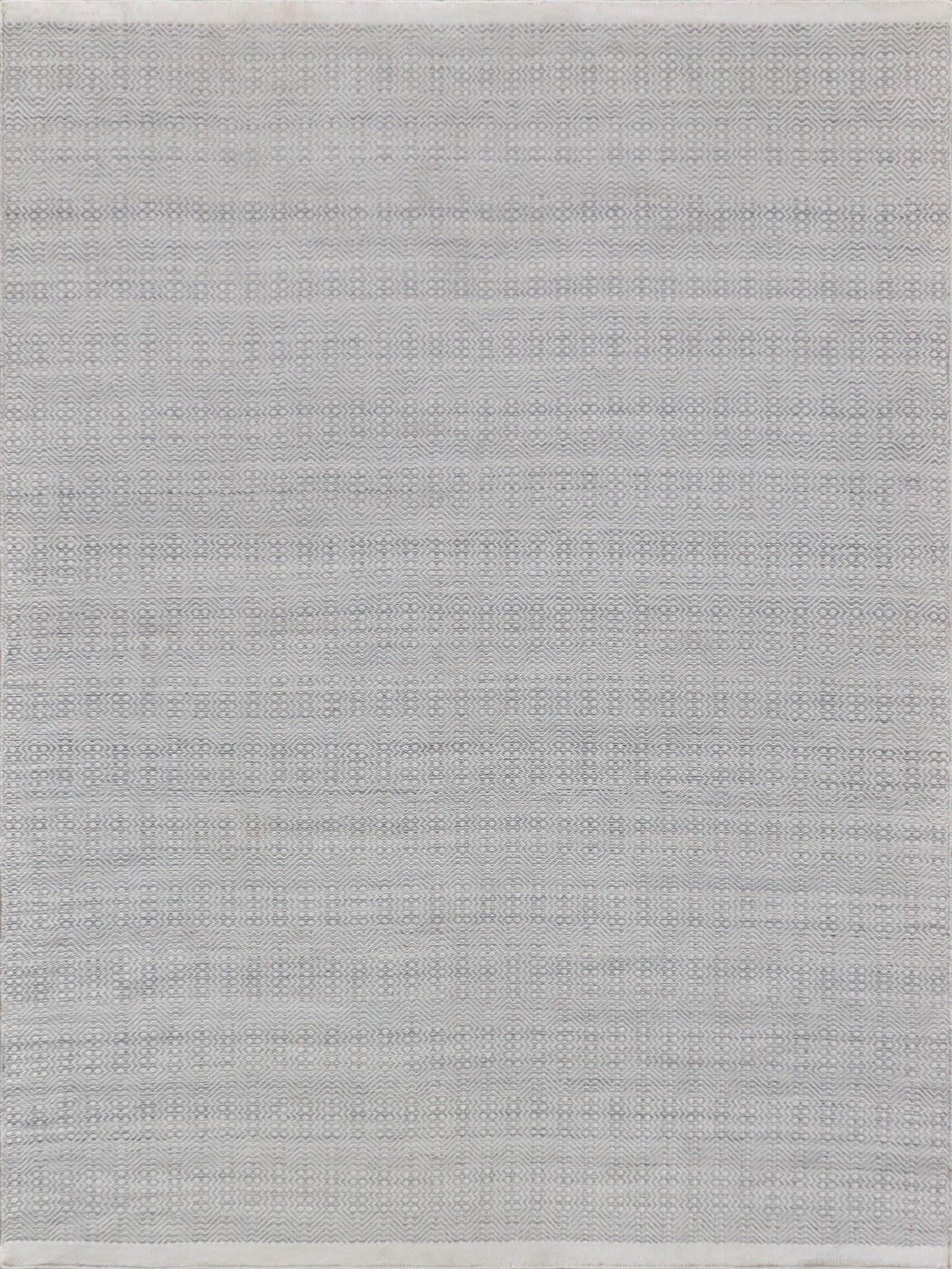 Light gray woven fabric rug featuring a subtle, textured pattern with fringed edges, perfect for modern home decor.