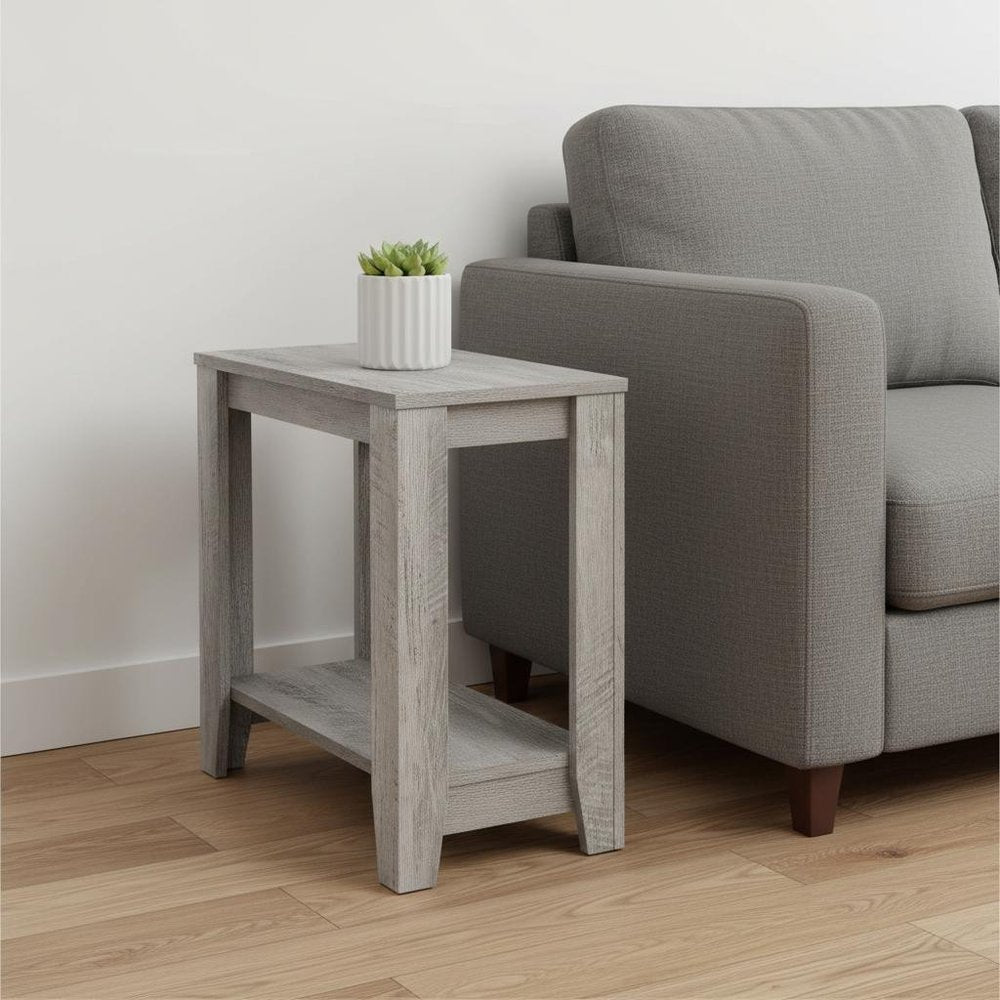 Light gray weathered wood end table with lower shelf beside a gray fabric sofa; white plant pot on top.