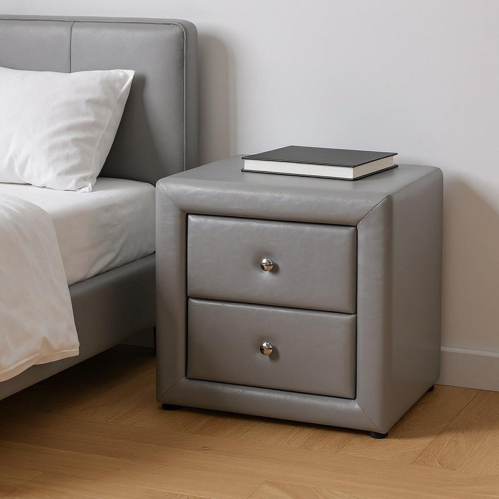 Gray wood two-drawer nightstand with silver knobs on a wooden floor, with a book on top.