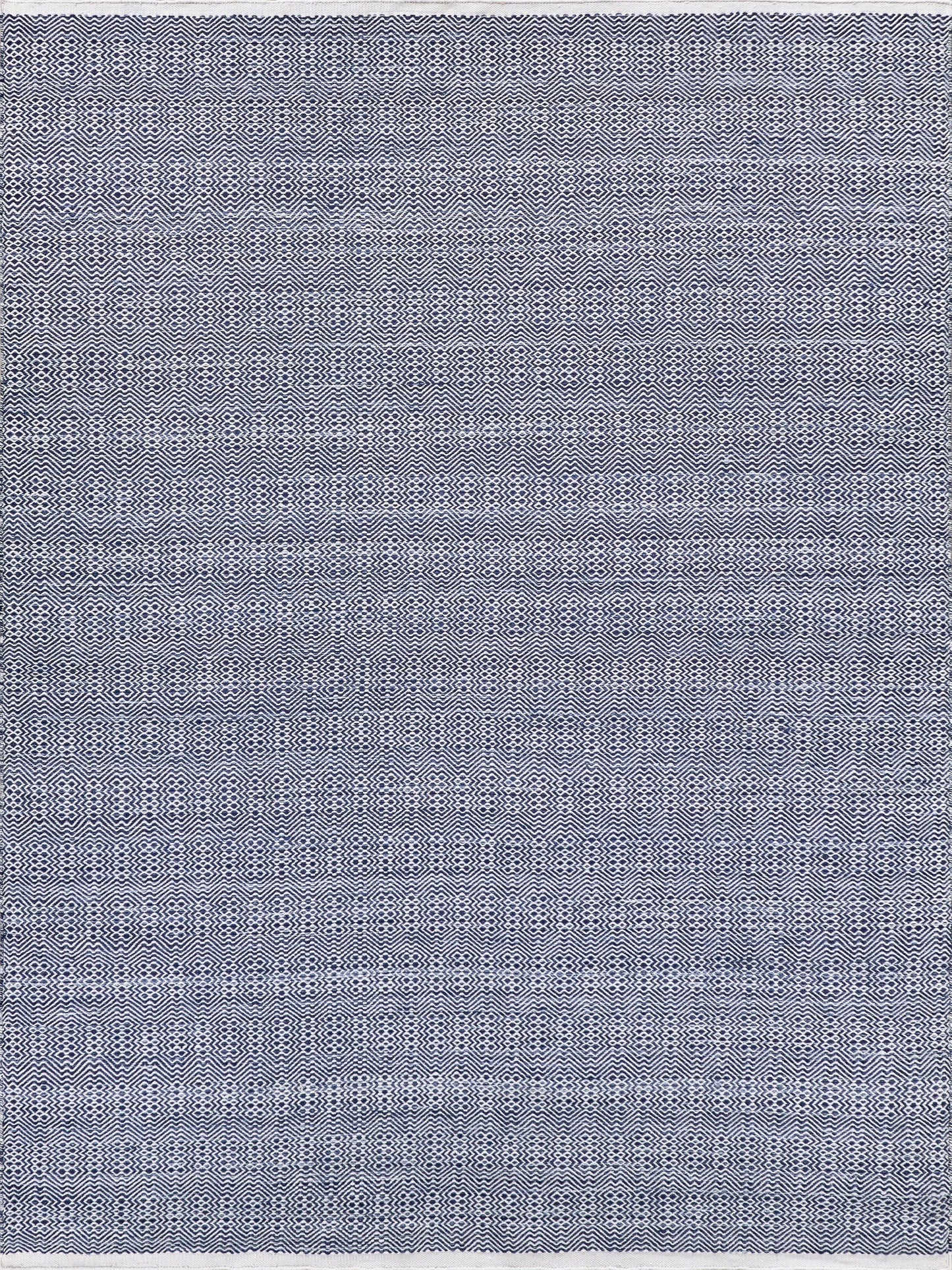 Navy and white flatweave rectangle rug with geometric pattern, woven texture, and fringed edges.