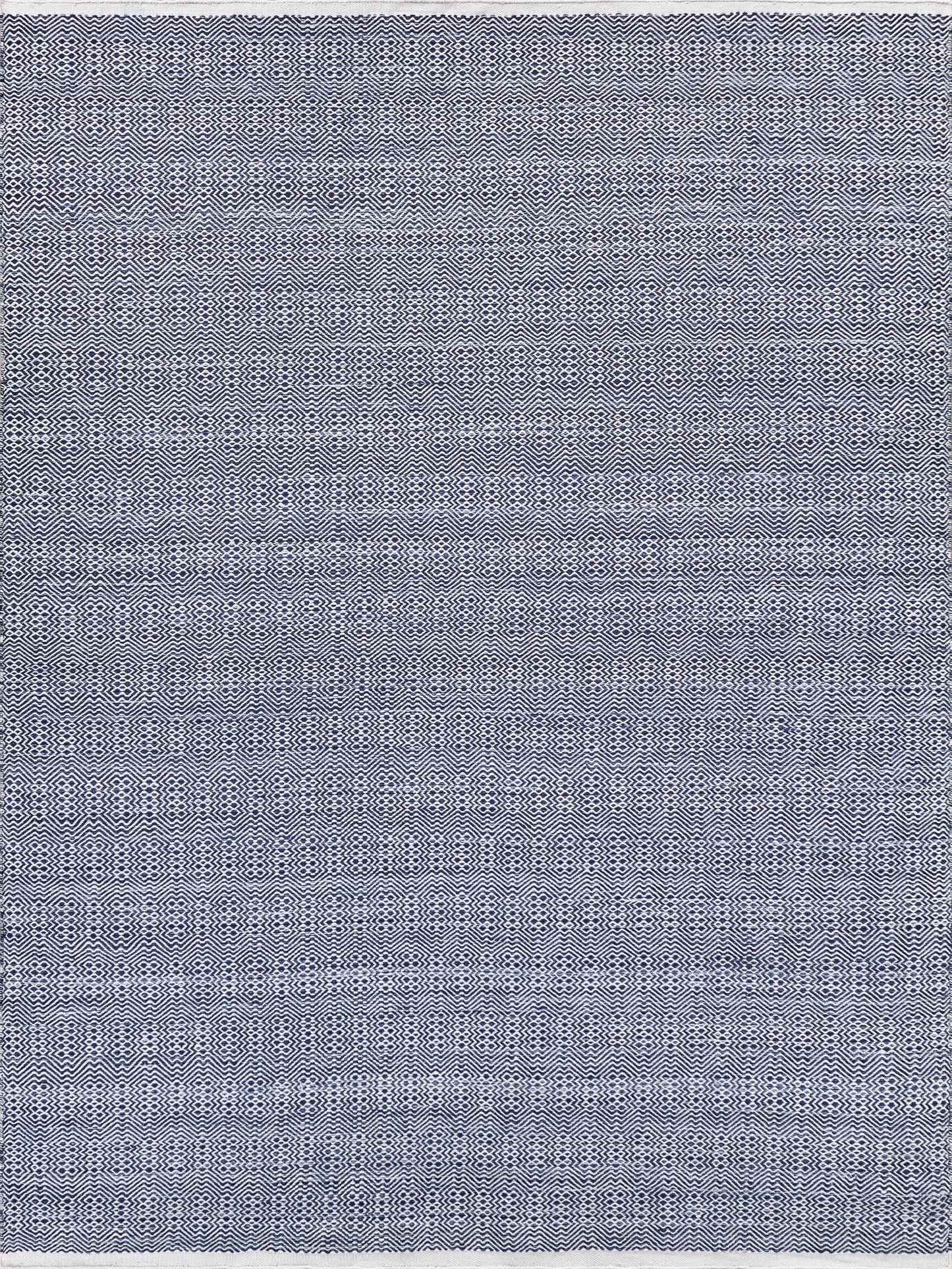 Navy blue and white geometric flatweave rug with a textured weave, rectangular.