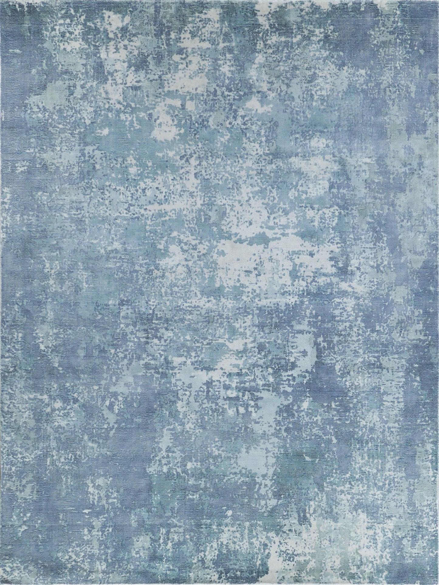 Blue distressed abstract rug with uneven light patches & faded denim tones.