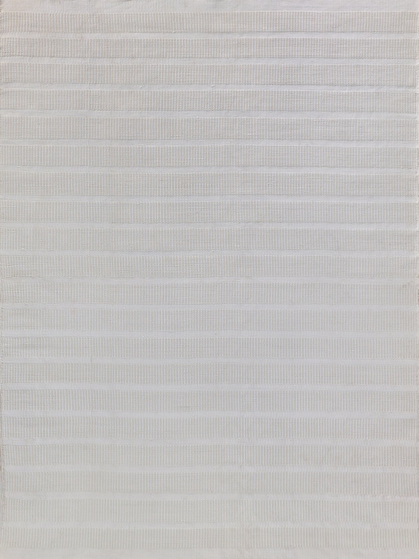 Rectangular flatweave rug in textured white with subtle horizontal stripes; soft woven surface.