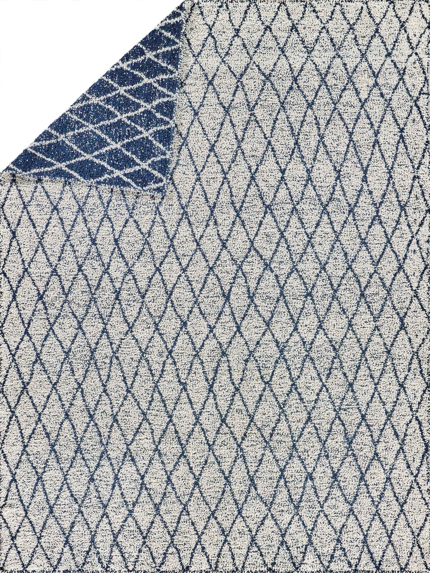 Geometric diamond lattice rug in blue over light gray, flat weave, contemporary style, folded corner reveals navy underside.