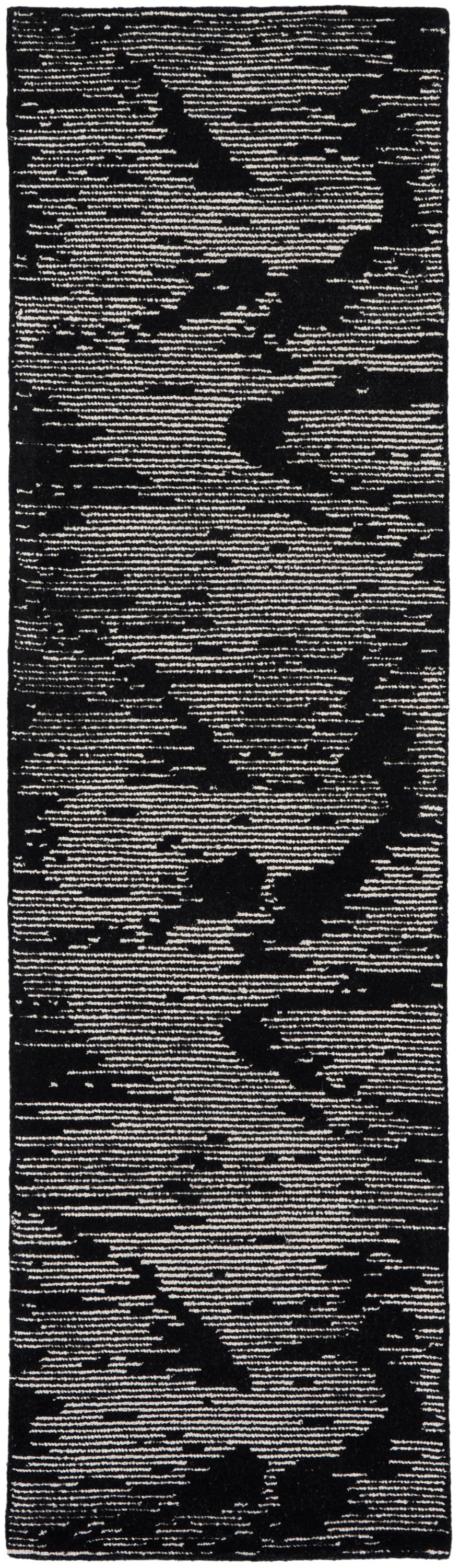 Black and cream abstract camo-like runner rug; narrow rectangular rug with textured pattern.