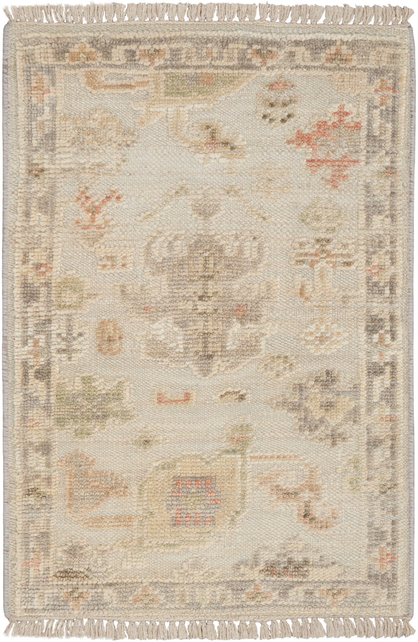 Rectangular cream-toned oriental rug with faded pastel medallion, floral motifs, and fringed ends; vintage-inspired decor.