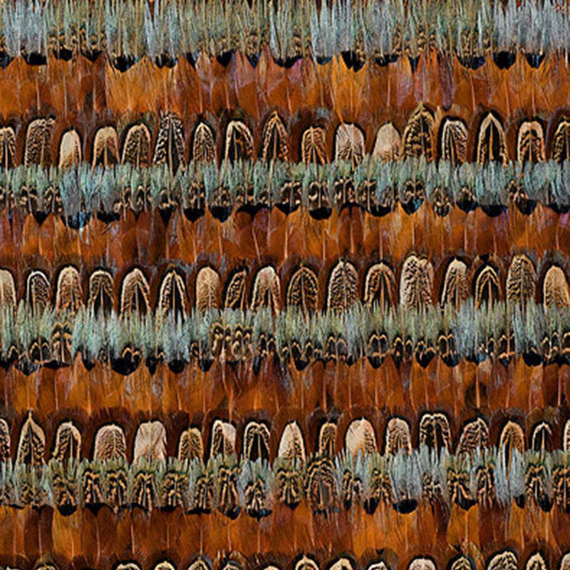 Close-up of a boho textile with brown rust and teal feather motifs arranged in rows.