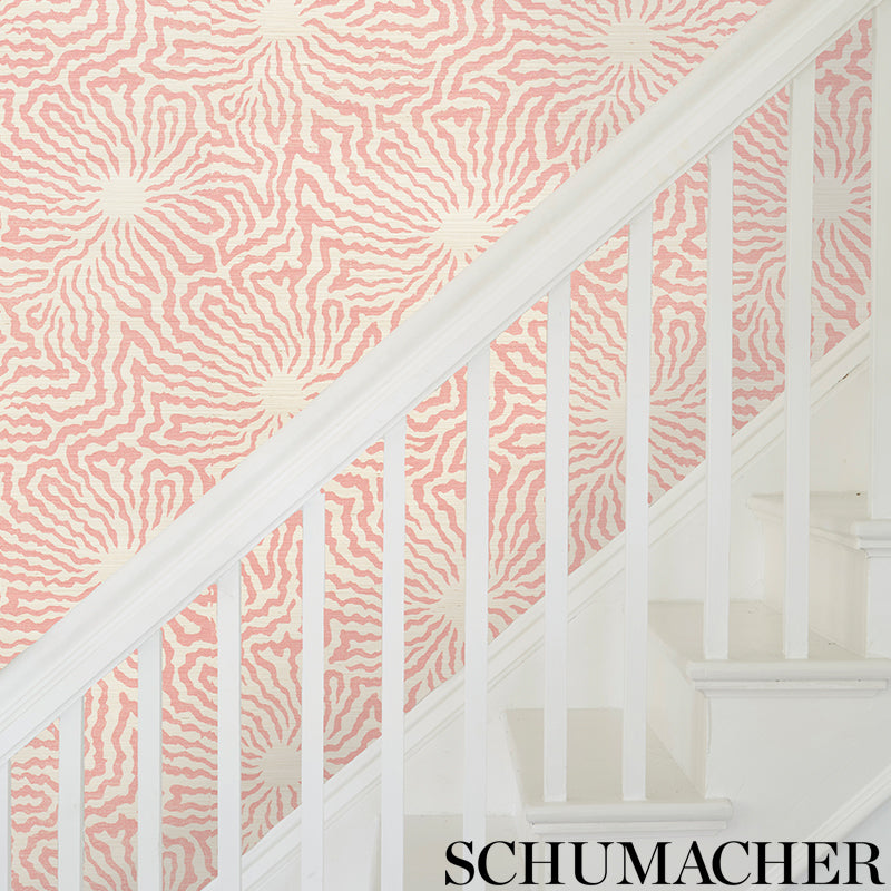 Pink and cream zebra-pattern wallpaper on staircase wall with white banister.
