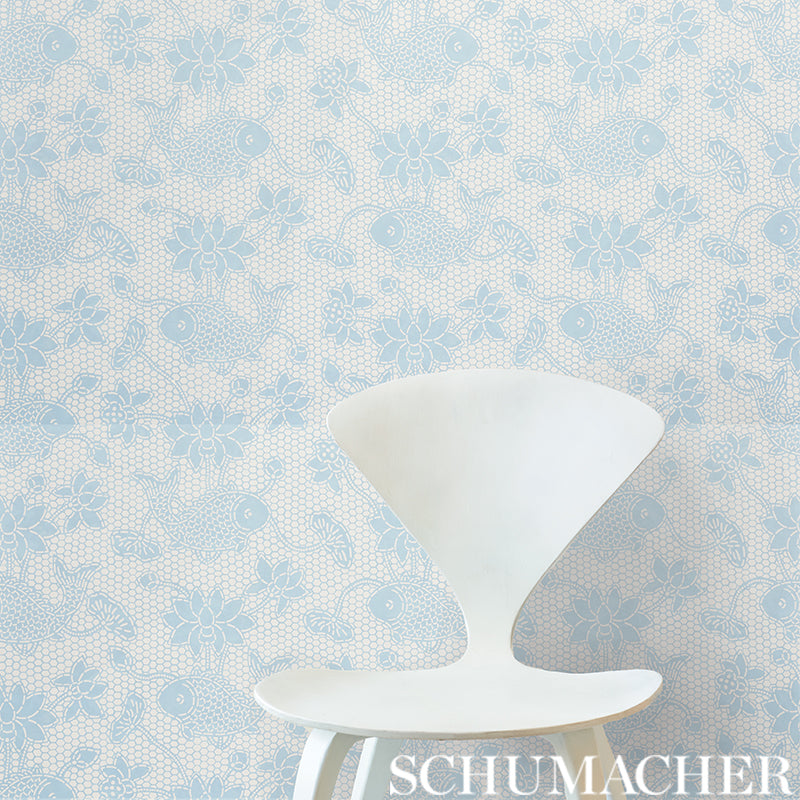 White sculptural chair with a wide conical back and curved seat, against pale blue floral wallpaper.