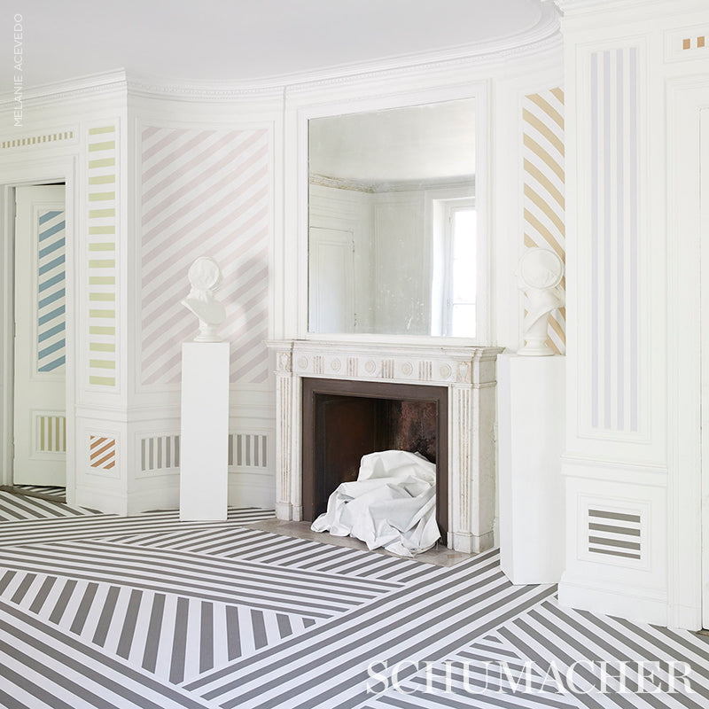 White room with pastel striped walls, ornate fireplace with large mirror, striped diagonal floor, pedestal bust.