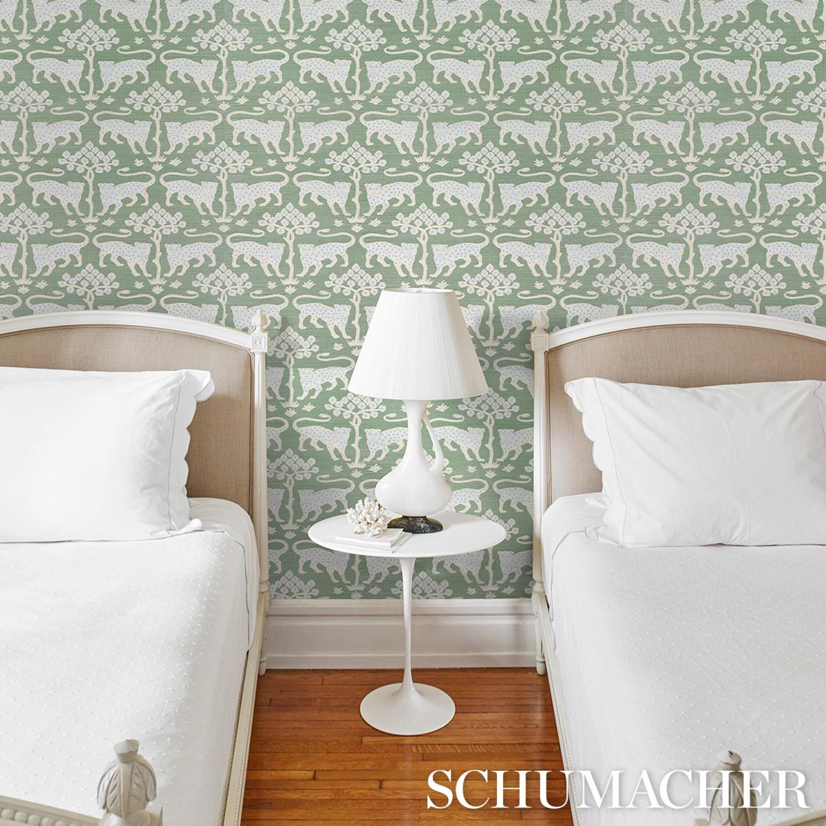 Luxury Schumacher Woodland Leopard Sisal Wallpaper in Seaglass featuring a sophisticated animal print with hand-drawn leopards and stylized trees on textured grasscloth sisal wallpaper. Elegant designer wallcovering for accent walls, powder rooms, dining rooms, bedrooms, entryways, boutique hotel interiors, modern traditional homes, and high-end interior design projects.