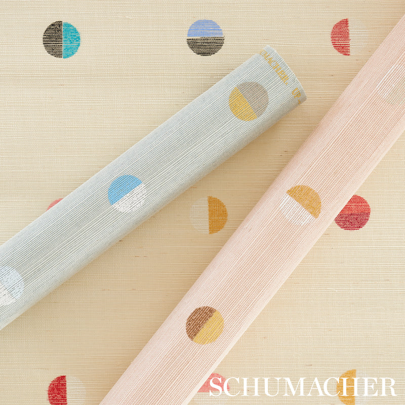 Two pastel linen-textured wallpaper rolls with geometric circle motifs in blue and pink.