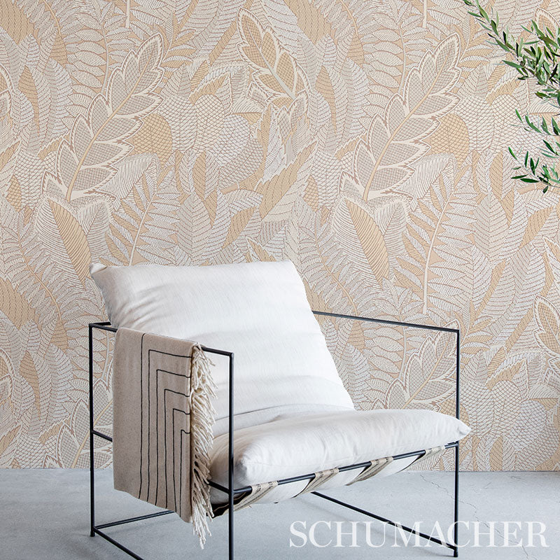 Minimalist black metal lounge chair with white cushions and beige tassel throw against leafy wallpaper.