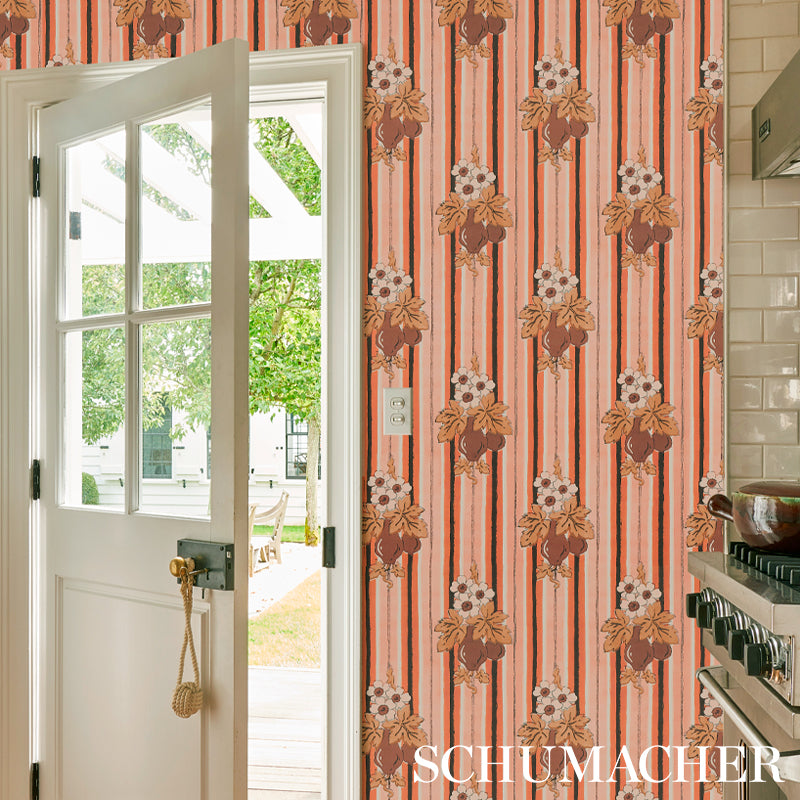 Schumacher vintage floral striped wallpaper in orange/brown tones on kitchen wall beside white glass-paneled door.