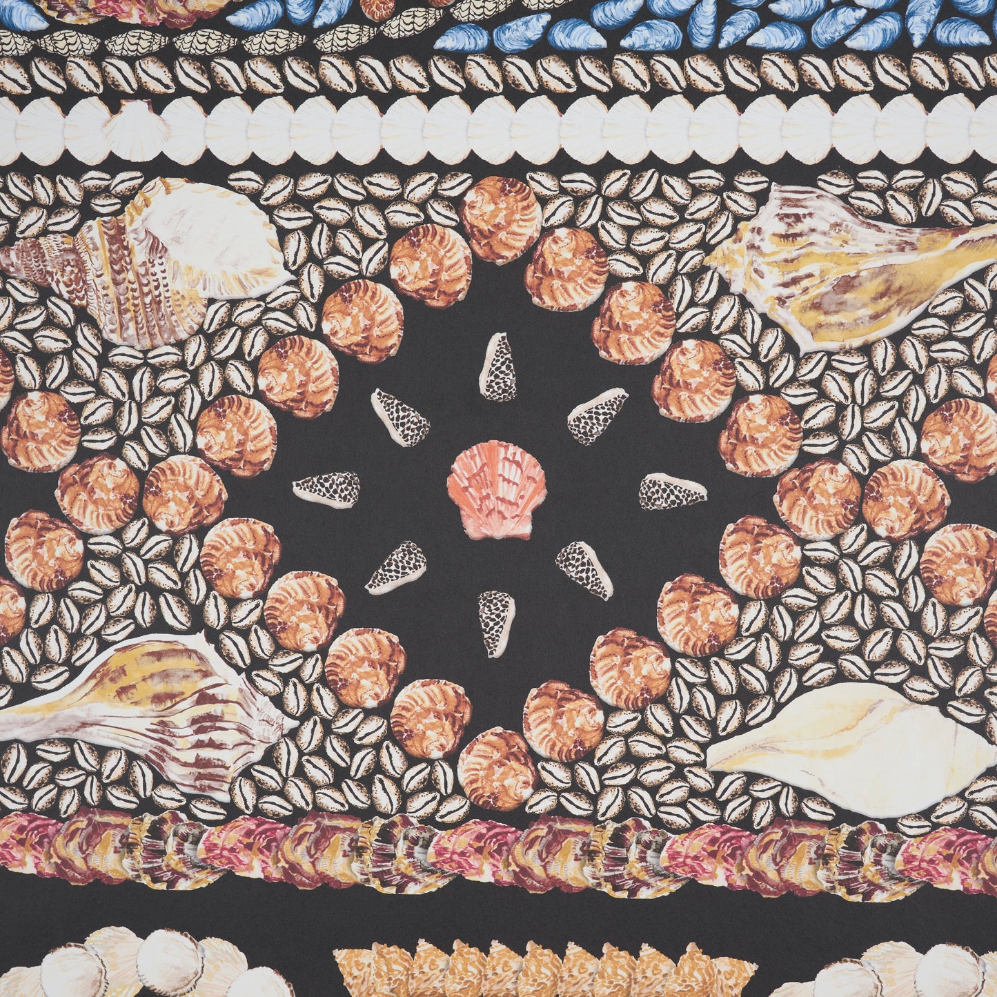 Panel design featuring a bold black central star motif, orange bead circles, shell-and-leaf motifs, and a blue and white border on an onyx multi background.