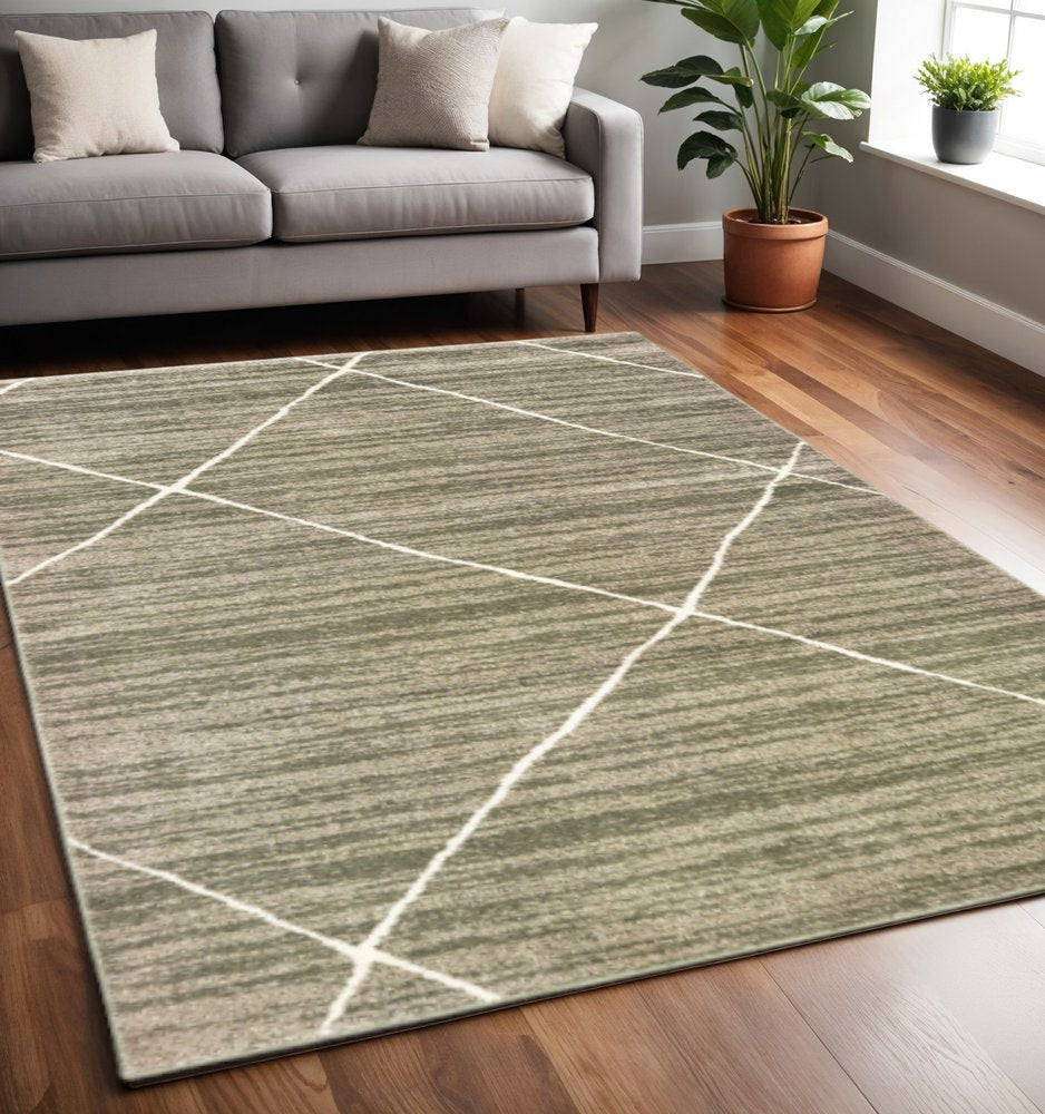 Grey and ivory geometric power-loom stained-resistant area rug (5' x 7') on hardwood floor in a living room, with a modern gray sofa and a plant nearby.