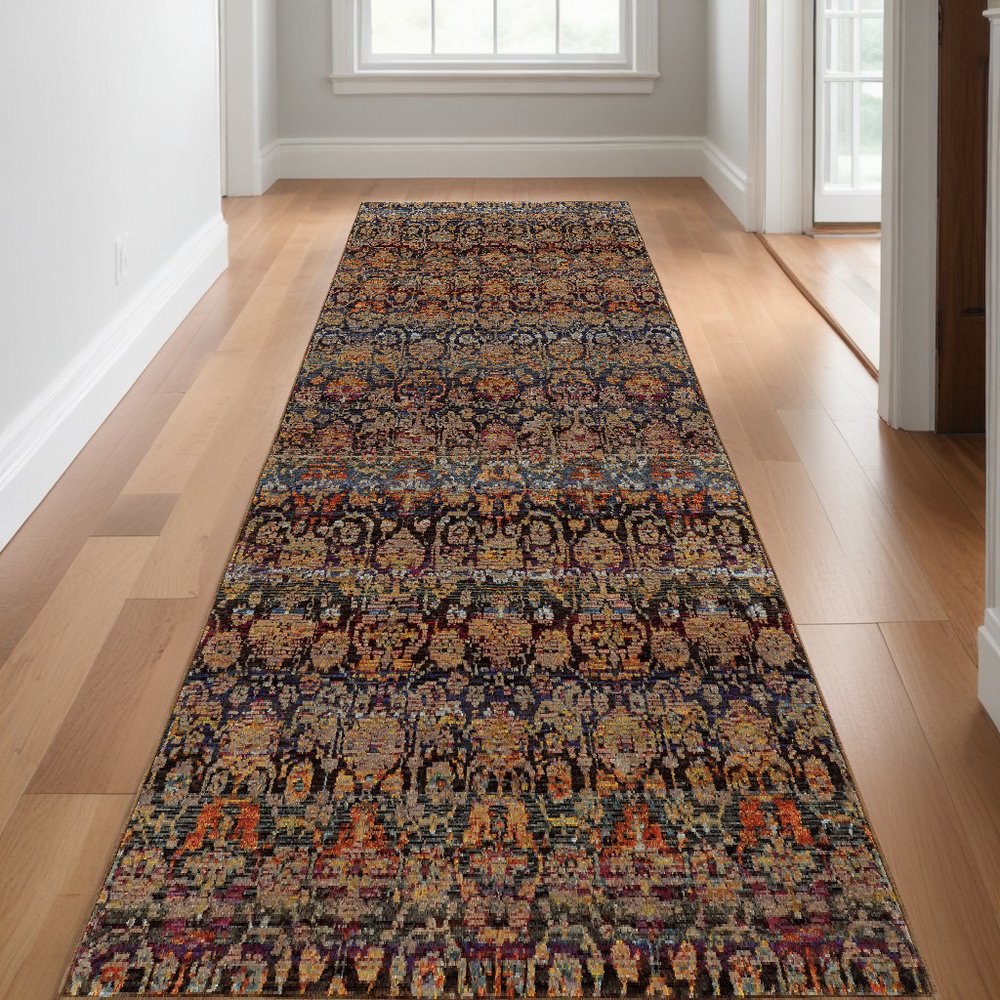 Long rectangular oriental-style runner rug on light hardwood hallway floor; intricate blue, cream, orange pattern.