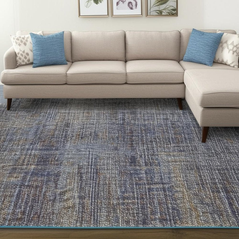 Beige fabric L-shaped sectional sofa with chaise on the right, blue accent pillows, and a blue-gray textured rug.
