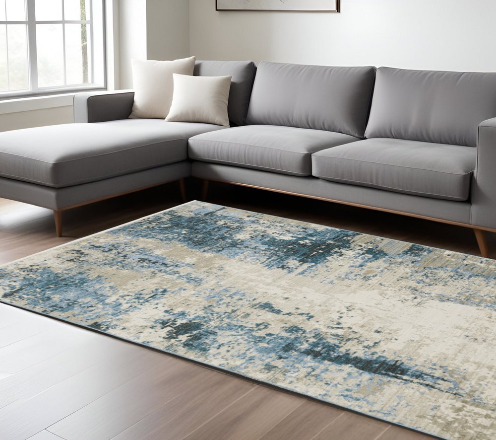 6' x 9' abstract blue, grey, ivory, light blue and dark blue power-loom area rug with fringe; stain-resistant.