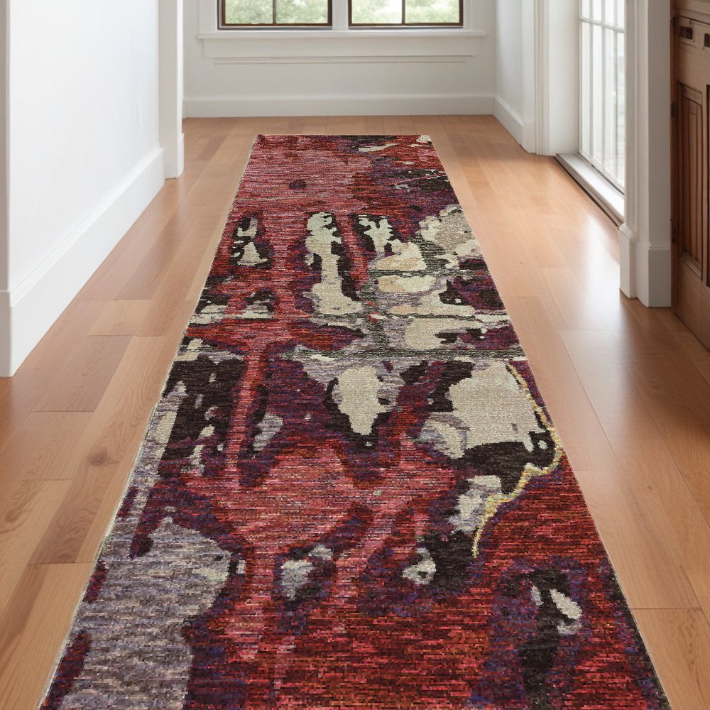 12' long rectangular runner rug in a hallway with a distressed abstract pattern in red and beige.