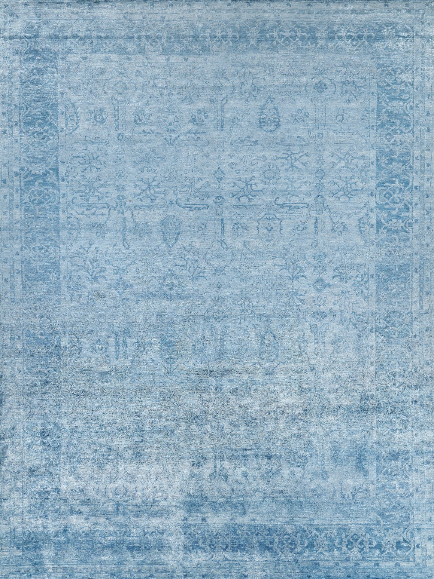 Light blue area rug featuring intricate patterns, soft texture, and a vintage style suitable for various decor.