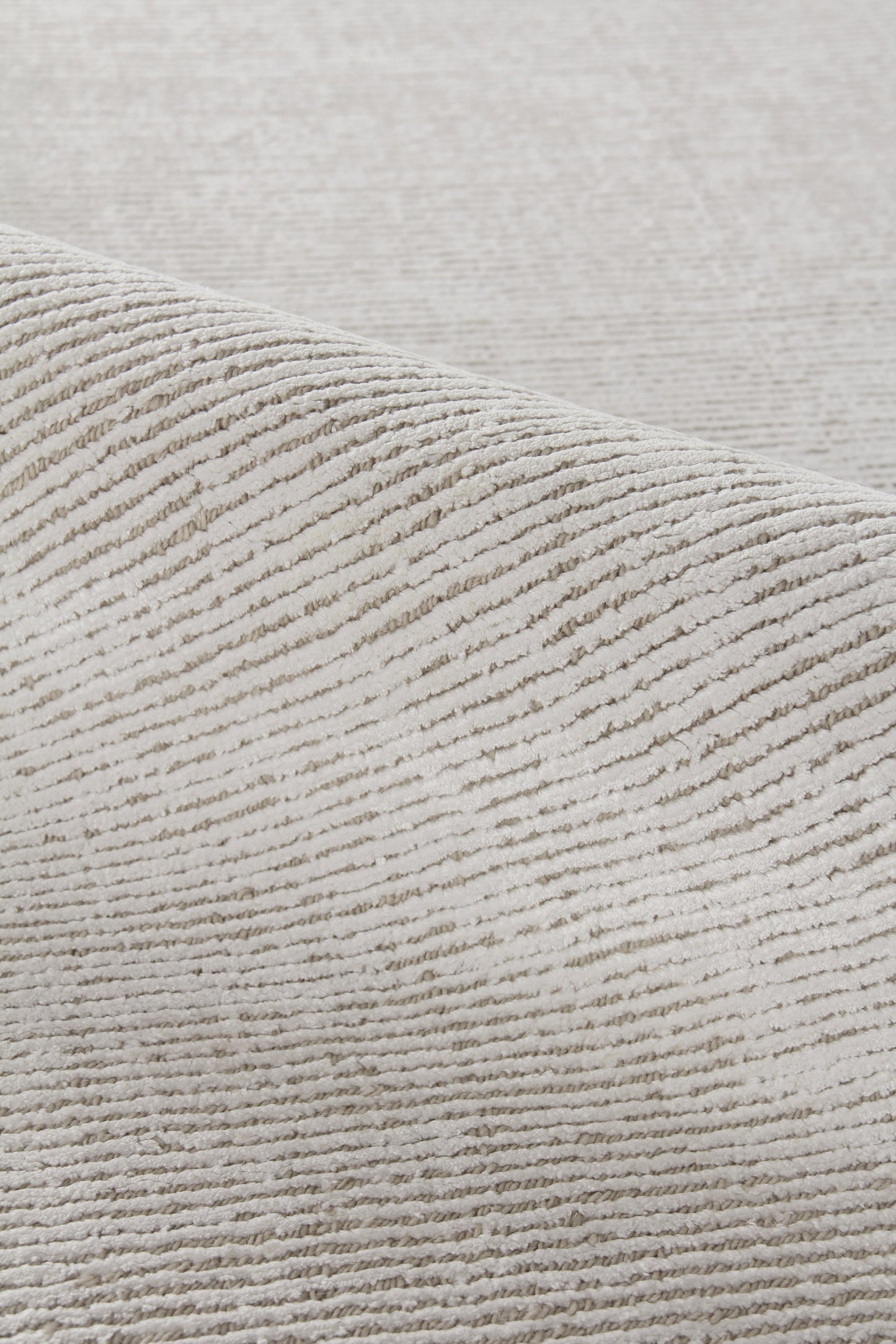 Beige rug close-up with thick ribbed, corduroy-style texture; hand-loomed indoor rug 2' x 3'.