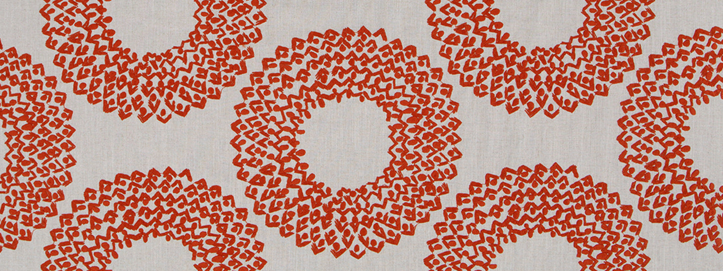 Cream background drapery fabric with repeating red circular floral ring motifs.