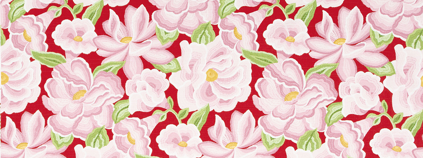 Vibrant floral fabric with pink blossoms and green leaves on a bold red background; floral print.