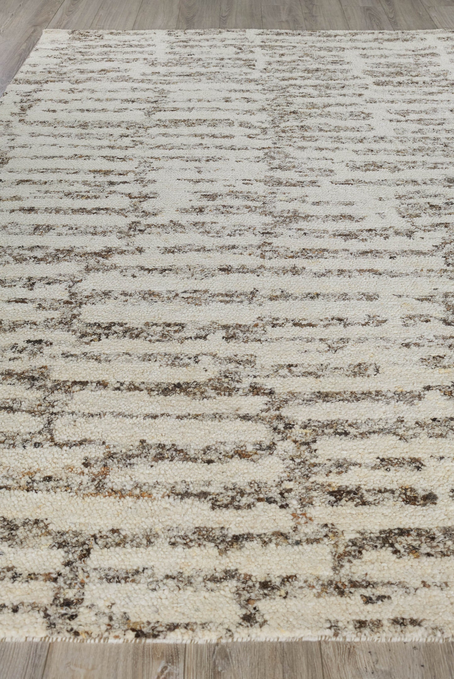 Beige cream area rug with abstract brown horizontal lines and a distressed pattern; modern living room decor.