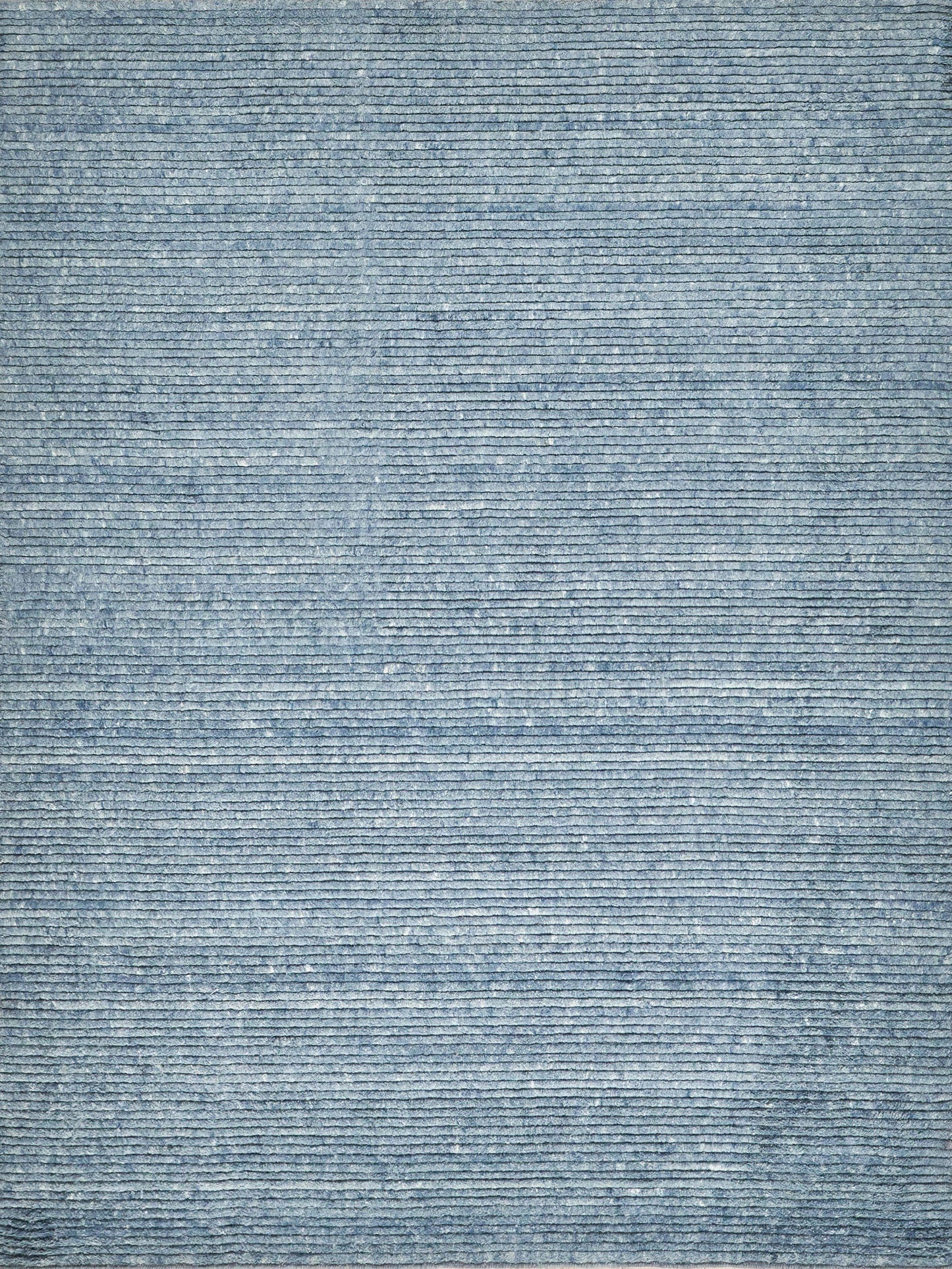 Blue woven rug with subtle horizontal striped texture and denim-blue tones, soft floor decor.