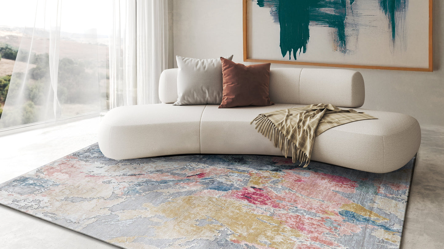 Hand-knotted rectangle rug with a vivid multicolor abstract pattern in a bright living room.