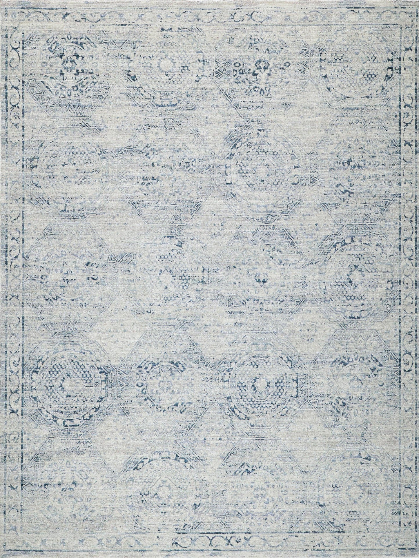 Distressed blue-and-white rug with faded medallion motifs and a decorative border.