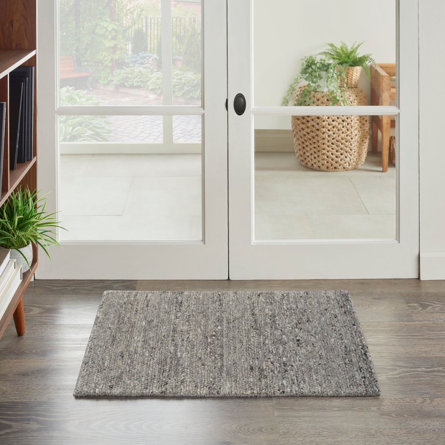 Rectangular gray textured entry rug on dark wood floor in front of white-framed French doors.